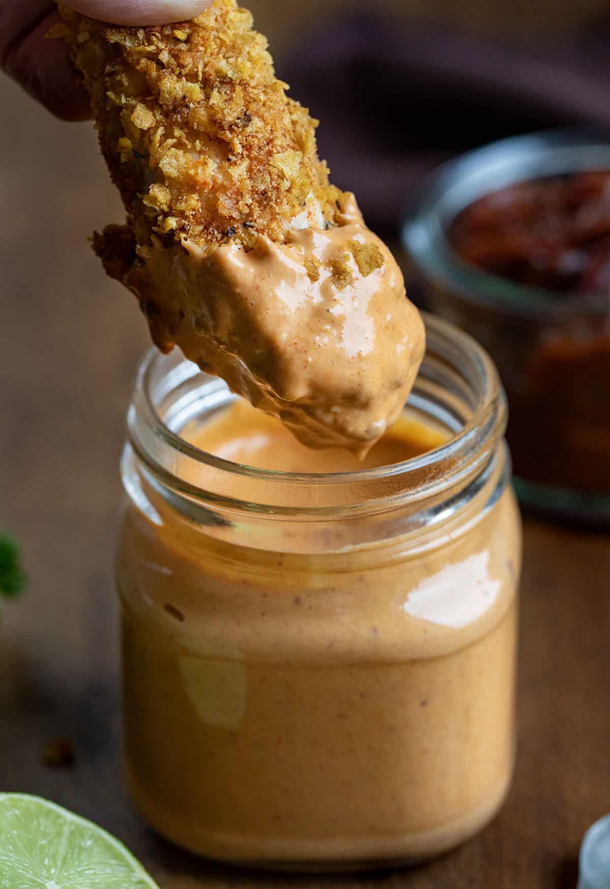 This Homemade Chipotle Mayo is creamy, smoky, and just the right amount of spicy with a touch of tangy lime and subtle sweetness. Dipping fried chicken into a jar of Chipotle Mayo.