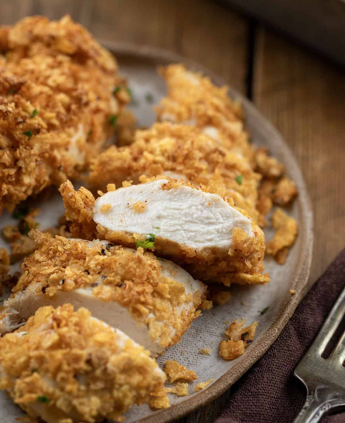 This Cornflake Chicken is crispy, golden, and baked, not fried, making it an easy weeknight dinner the whole family will love. Simple pantry ingredients come together for a no-fuss meal that’s big on flavor and short on prep time! Cut up piece of Cornflake Chicken showing how tender and juicy the chicken is.
