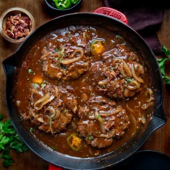 Skillet of Cowboy Salisbury Steak on a wooden table from overhead.