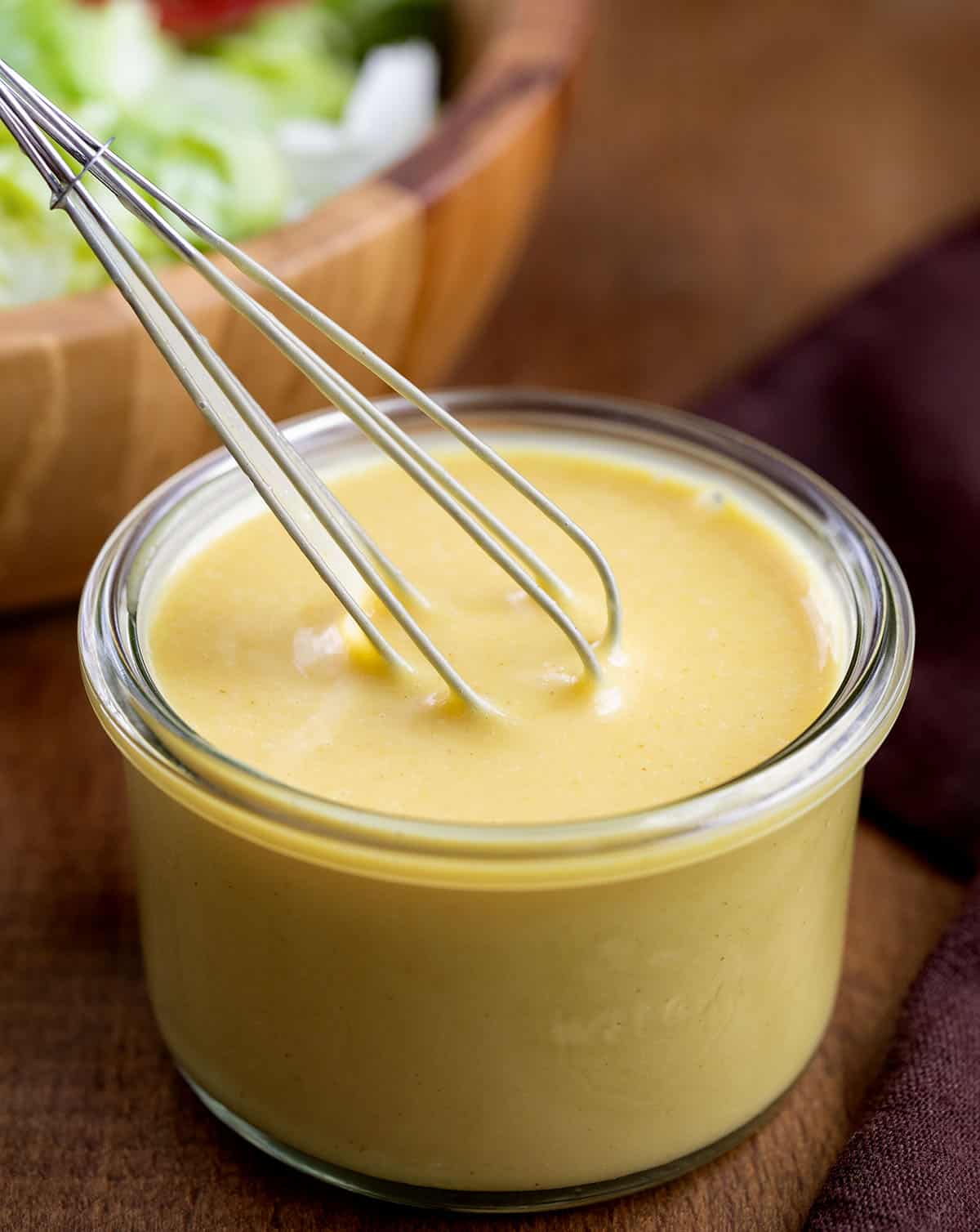 Whisking together Honey Mustard Dressing in a small glass jar.