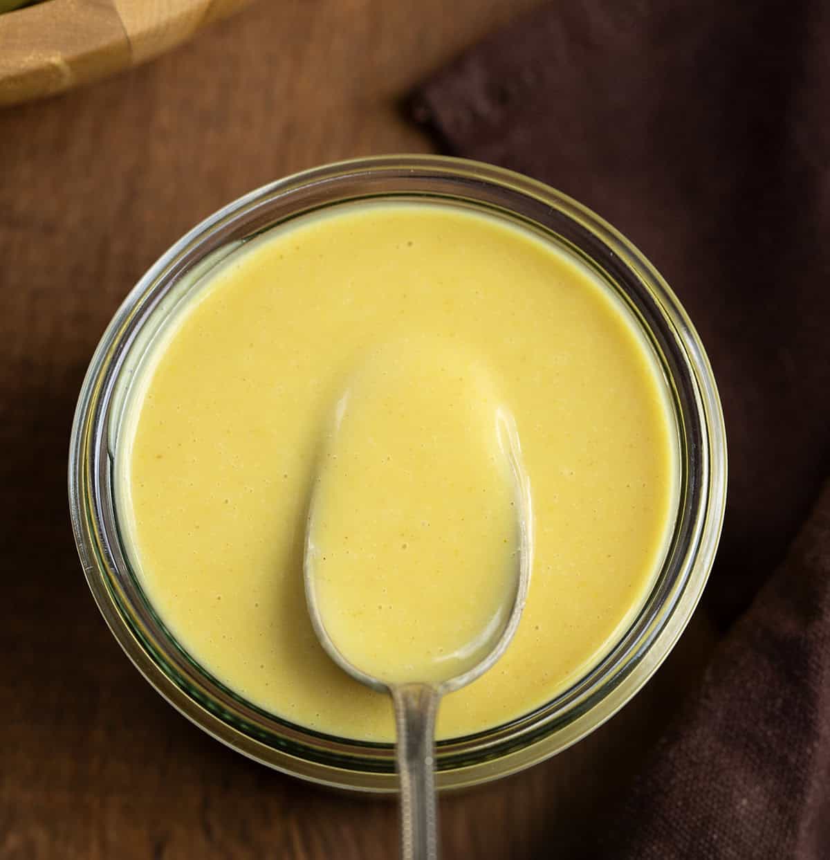 Spoon in a jar of Honey Mustard Dressing.