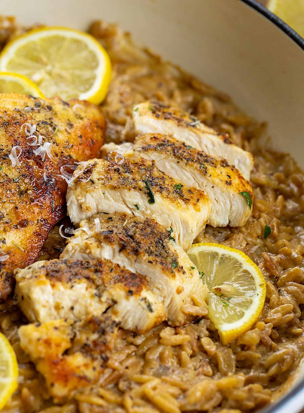 Diced Lemon Chicken on a bed of creamy orzo with fresh lemon in a skillet Diced Lemon Chicken on a bed of creamy orzo with fresh lemon in a skillet.
