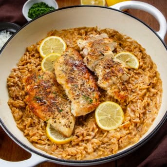 White Skillet of Lemon Chicken Orzo on a wooden table.