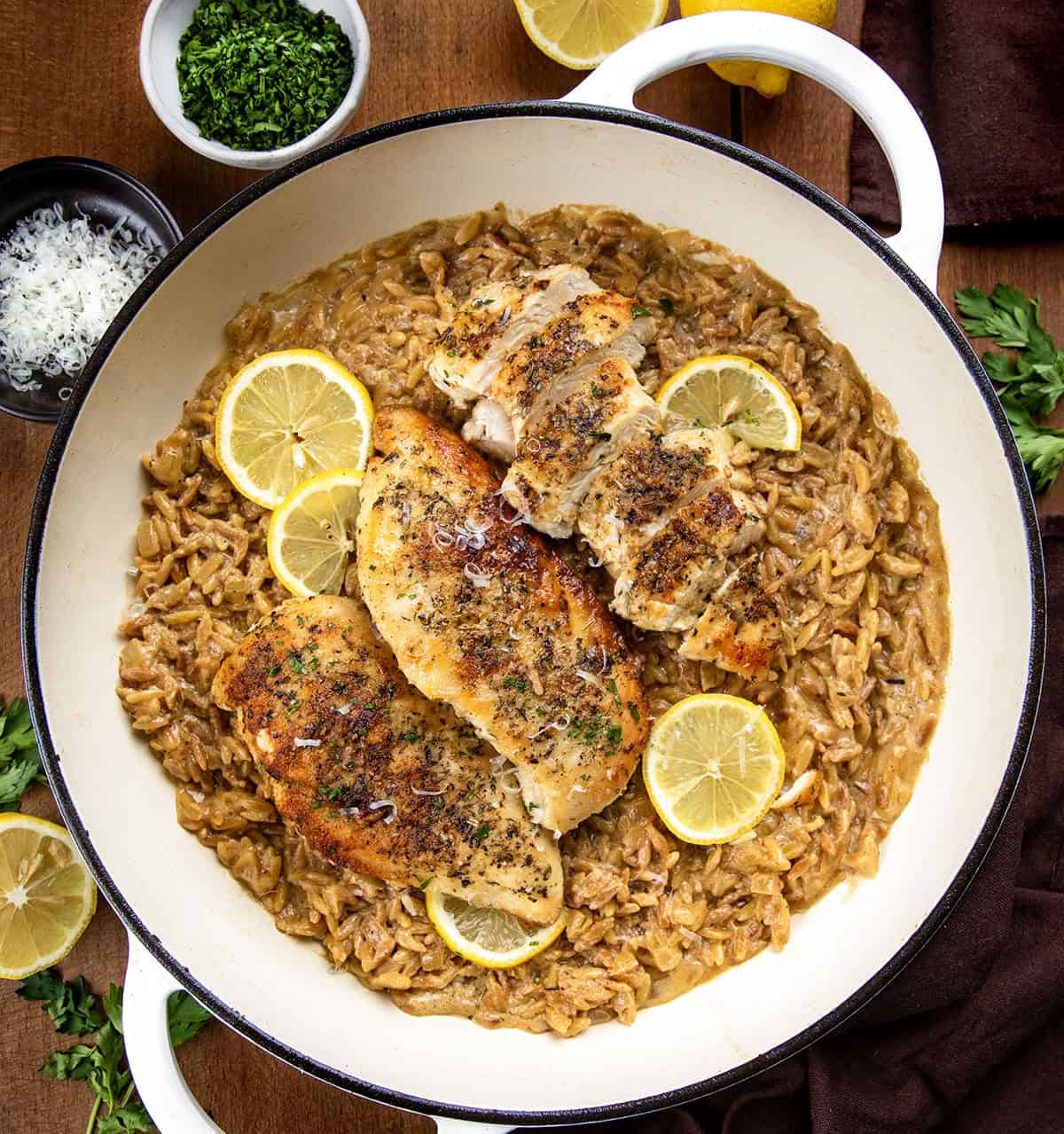 Lemon Chicken Orzo in a skillet on a wooden table from overhead Lemon Chicken Orzo in a skillet on a wooden table from overhead.