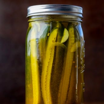 One jar of Mustard Pickles on a wooden table.
