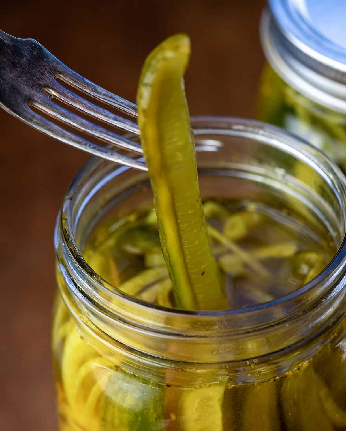 These Mustard Pickles are crisp, sweet, and tangy with a bold mustard flavor and that signature golden color. They’re incredibly easy to make with a simple hot brine and no canning required; just pour, chill, and let the flavors develop in the refrigerator! Fork picking up a Mustard Pickle spear from the jar.
