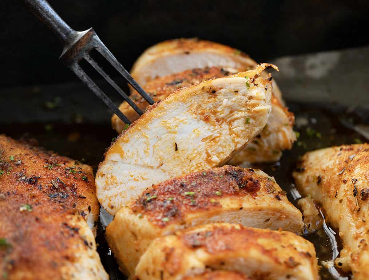 Fork licking up a piece of Oven Baked Chicken Breast.