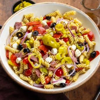 Bowl of Pepperoncini Pasta Salad on a wooden table.