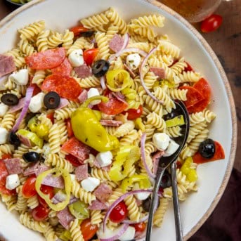 Large bowl of Pepperoncini Pasta Salad with salad tongs in it from overhead.