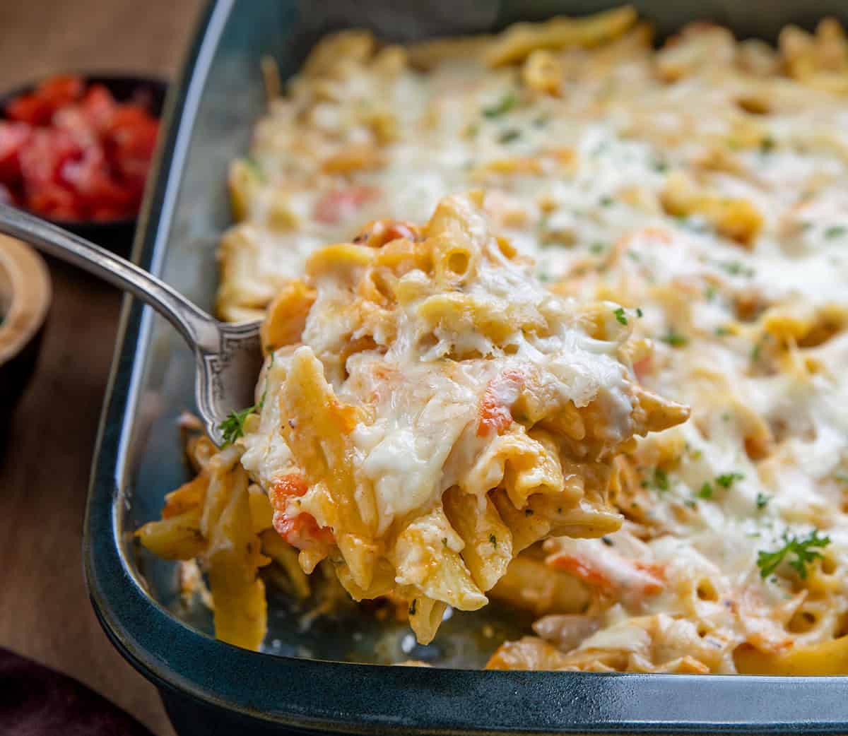 This Creamy Seafood Pasta Bake is a rich, comforting baked pasta loaded with tender shrimp, imitation crab, and a creamy Monterey Jack cheese sauce. It’s baked until bubbly and golden on top, making it an easy yet impressive dinner that’s perfect for seafood lovers! Picking up a scoop of Seafood Pasta Bake from the pan.