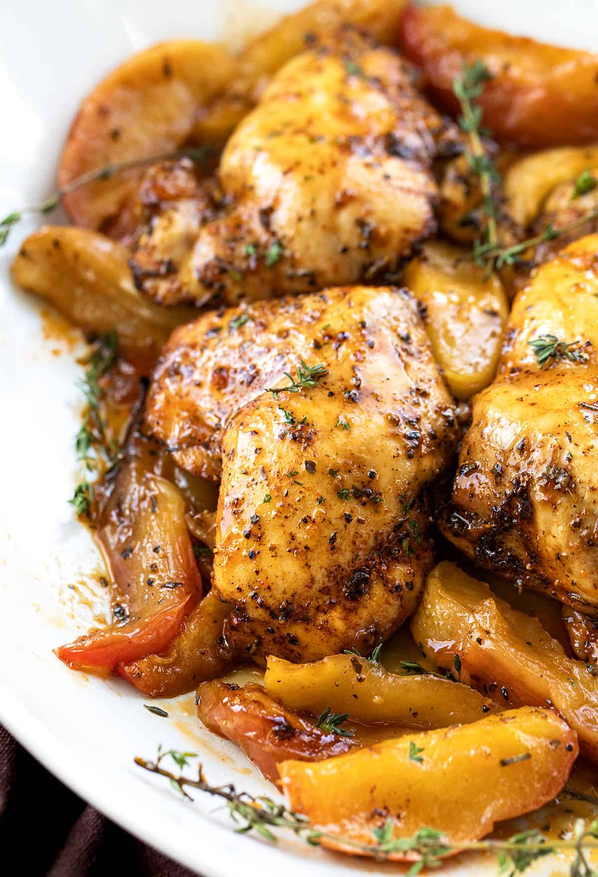 Close up of Sheet Pan Apple Chicken in a white dish.