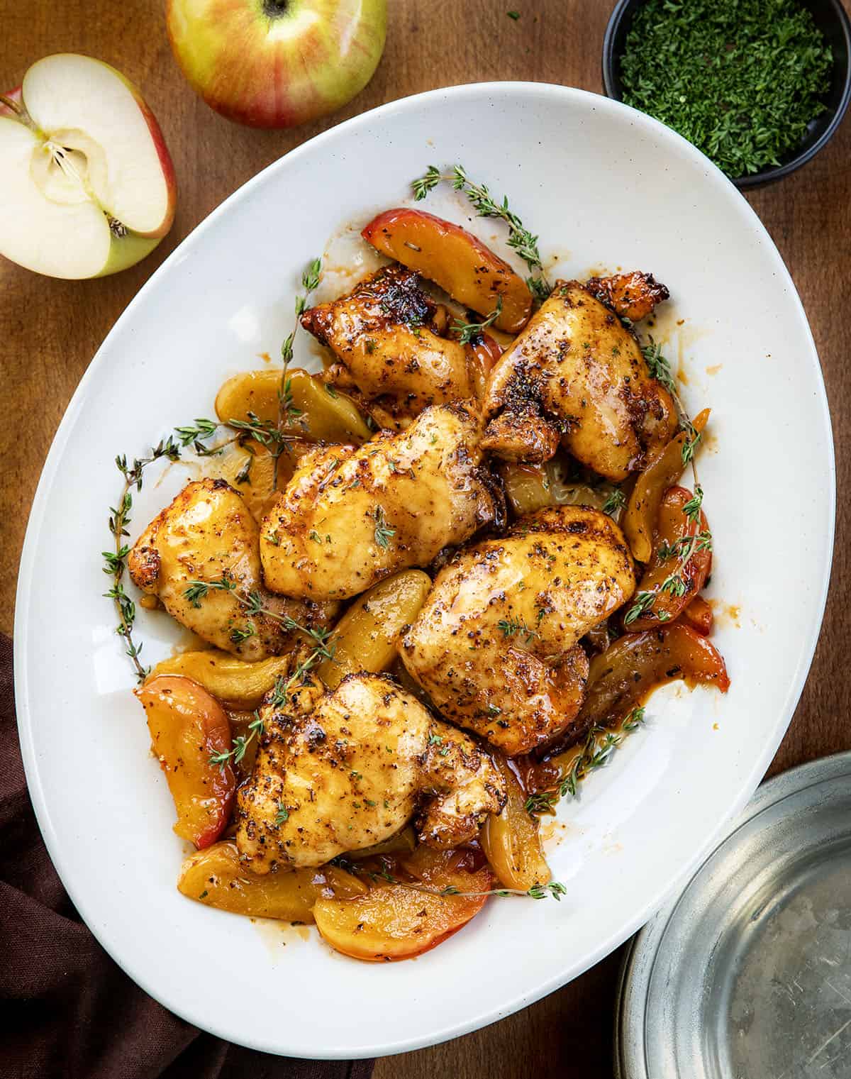 White platter filled Sheet Pan Apple Chicken on a wooden table.