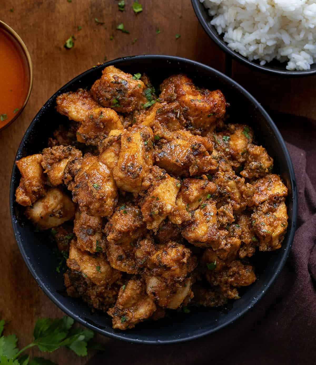 This Sheet Pan Buffalo Chicken is one of those easy, high-flavor dinners that hits all the right notes! You get tender, juicy chicken, and plenty of bold buffalo flavor in every bite! Black bowl of Sheet Pan Buffalo Chicken on a wooden table.