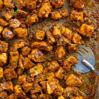 Sheet Pan Buffalo Chicken close up with a spatula on the pan.