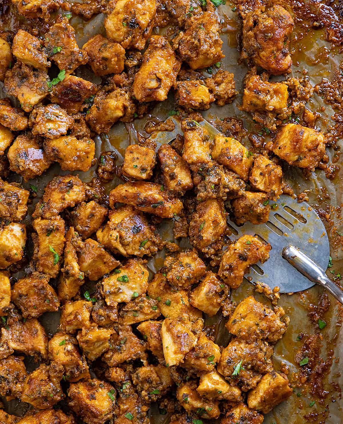 This Sheet Pan Buffalo Chicken is one of those easy, high-flavor dinners that hits all the right notes! You get tender, juicy chicken, and plenty of bold buffalo flavor in every bite! Sheet Pan Buffalo Chicken close up with a spatula on the pan.