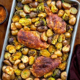 One pan Blackened Chicken and Brussels Sprouts on a wooden table from overhead.