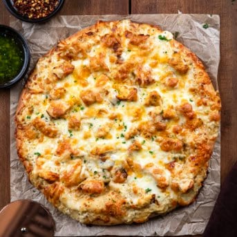 Whole Chicken Alfredo Pizza on a wooden table from overhead.
