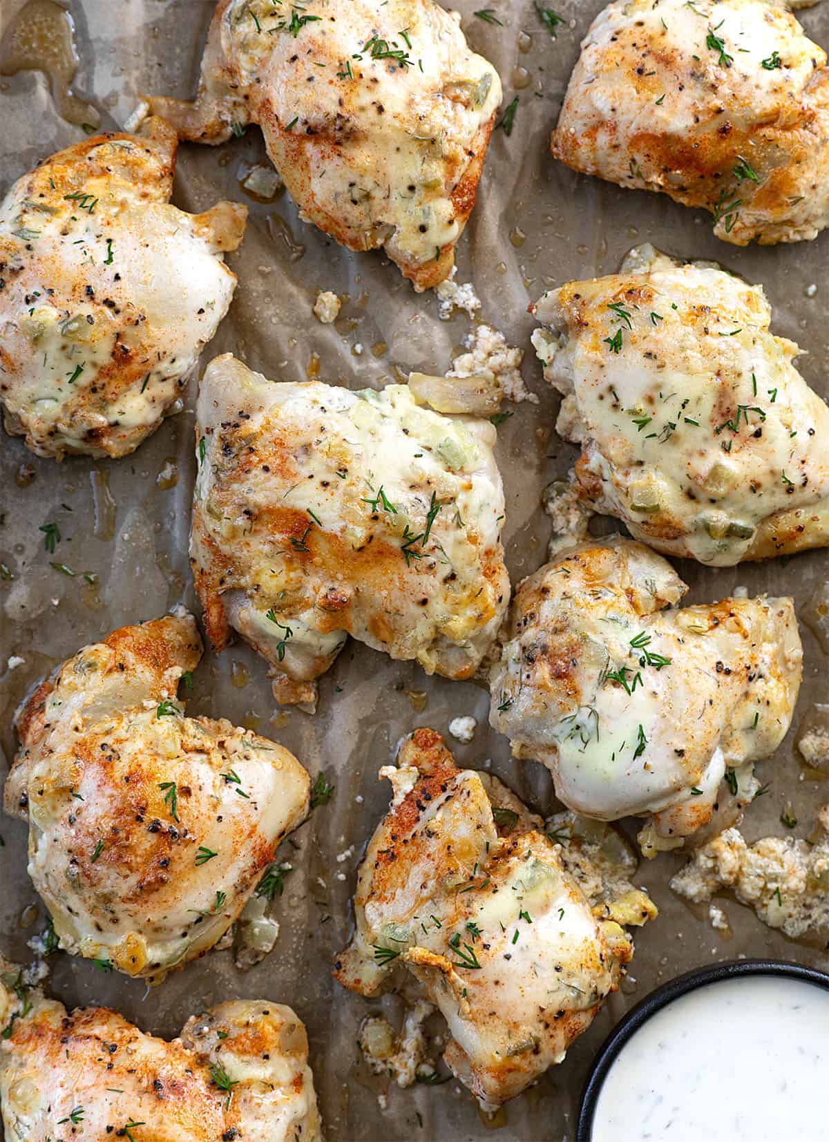 If you love pickles and ranch, this Dill Pickle Ranch Chicken is about to be your new obsession! Juicy chicken thighs are soaked in dill pickle juice for maximum tang and tenderness, then brushed with my creamy homemade Dill Pickle Ranch Dressing and cooked until perfectly golden! Dill Pickle Ranch Chicken on a sheet pan from overhead.