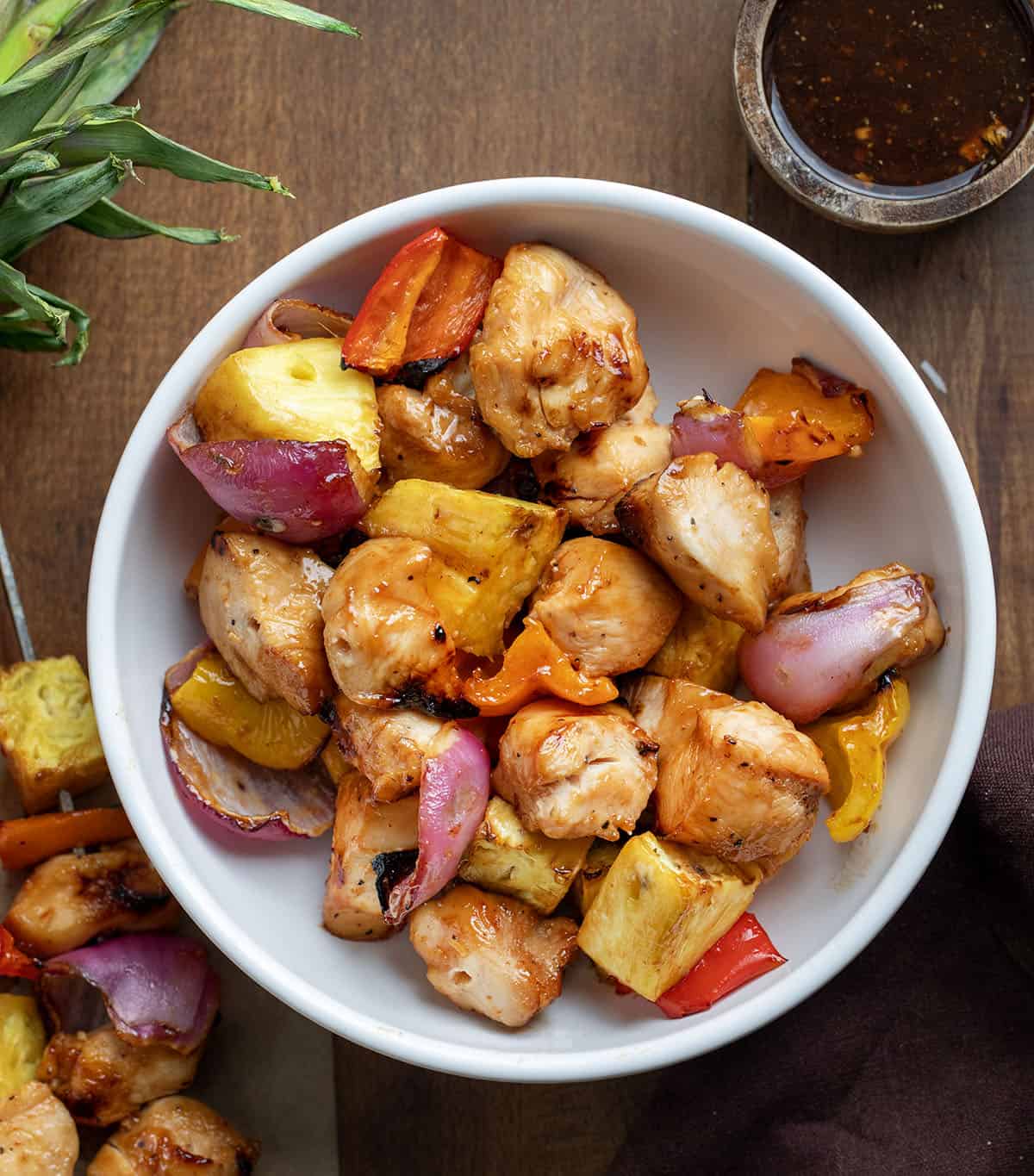 Bowl of chicken and vegetables from Hawaiian Chicken Skewers on a wooden table Bowl of chicken and vegetables from Hawaiian Chicken Skewers on a wooden table.