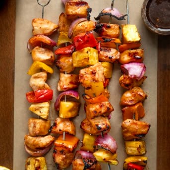 Hawaiian Chicken Skewers on a wooden table from overhead.