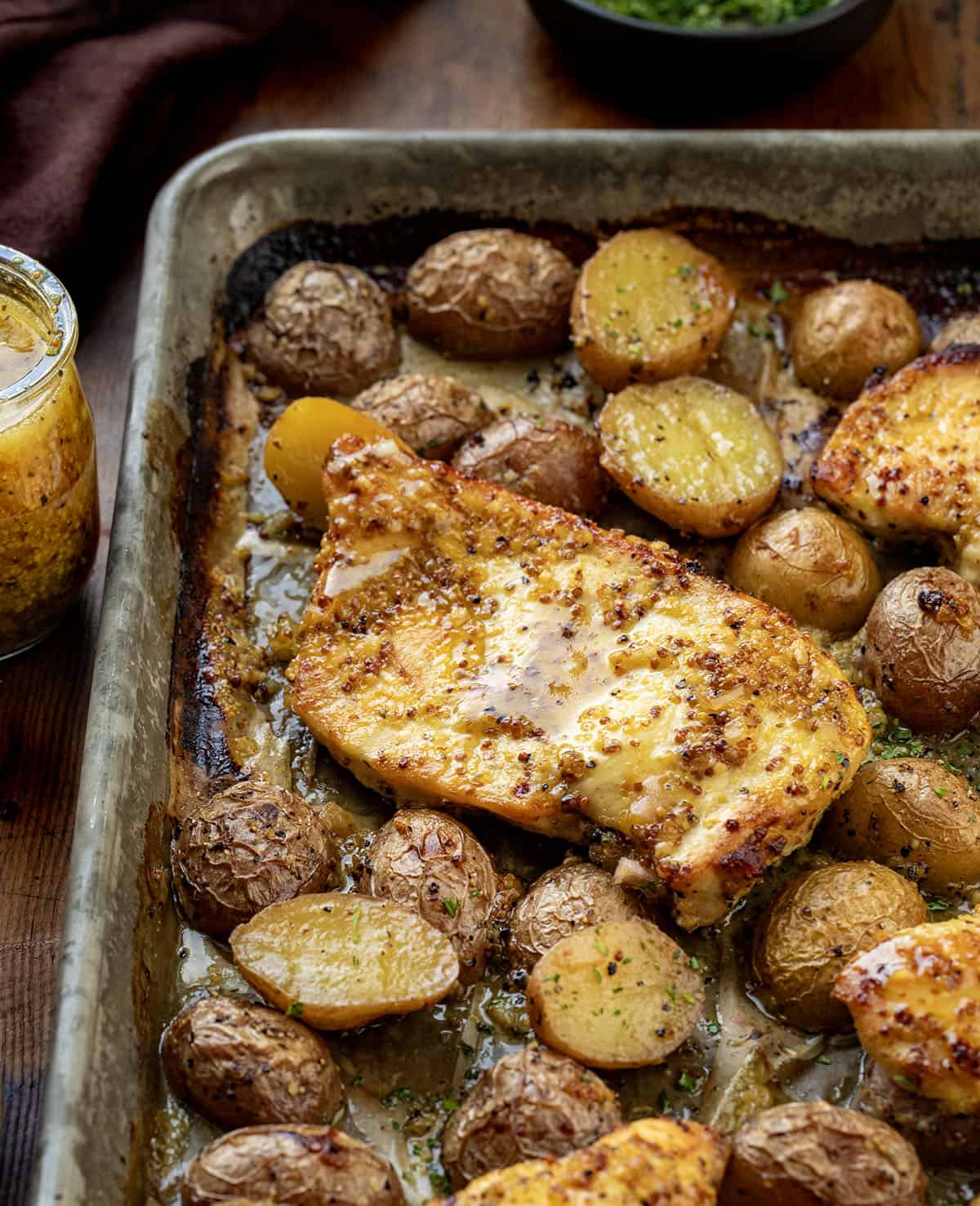 This One Pan Honey Mustard Chicken and Potatoes is an easy sheet pan dinner made with juicy marinated chicken, crispy roasted potatoes, and a sweet-tangy honey mustard glaze! Honey Mustard Chicken and POtatoes close up.