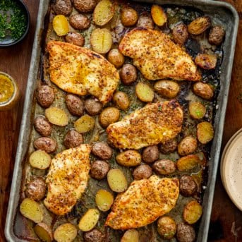 Honey Mustard Chicken and POtatoes on a sheet pan on a wooden table from overhead.