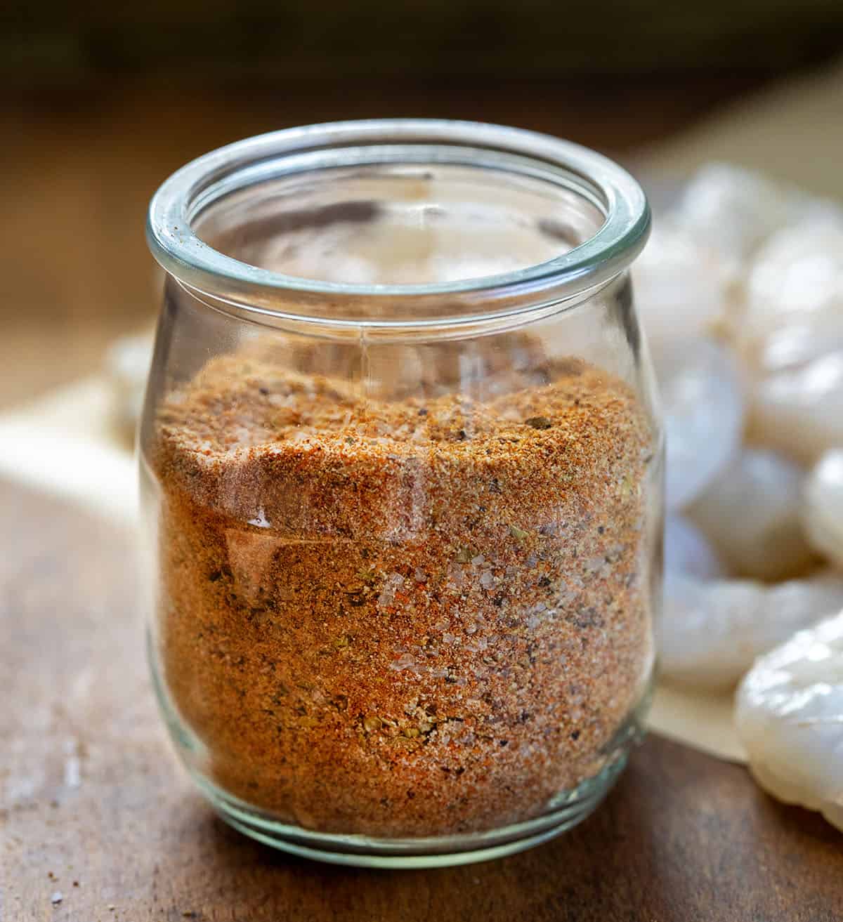 Jar of Shrimp Seasoning with some raw shrimp in the background Jar of Shrimp Seasoning with some raw shrimp in the background.