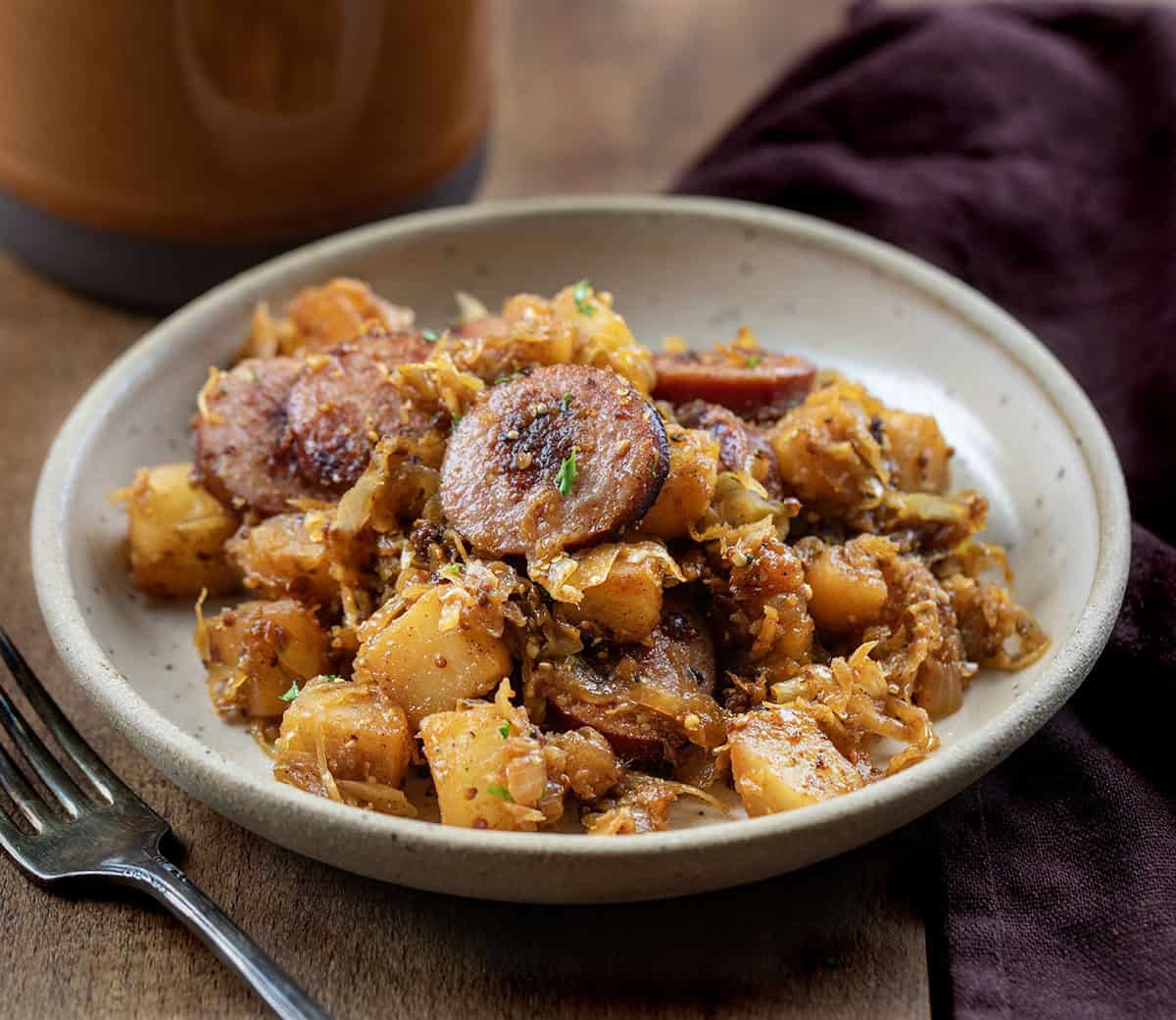 Plate of Skillet Kielbasa and Sauerkraut on a wooden table close up Plate of Skillet Kielbasa and Sauerkraut on a wooden table close up.