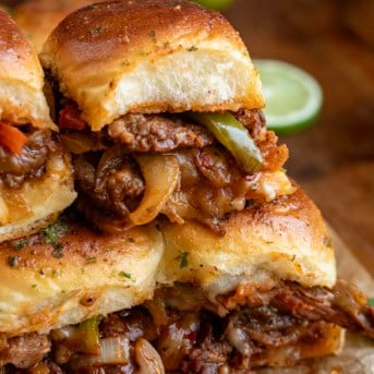 Stacked Steak Fajita Sliders on a wooden table.