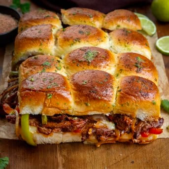 Steak Fajita Sliders on a wooden table.