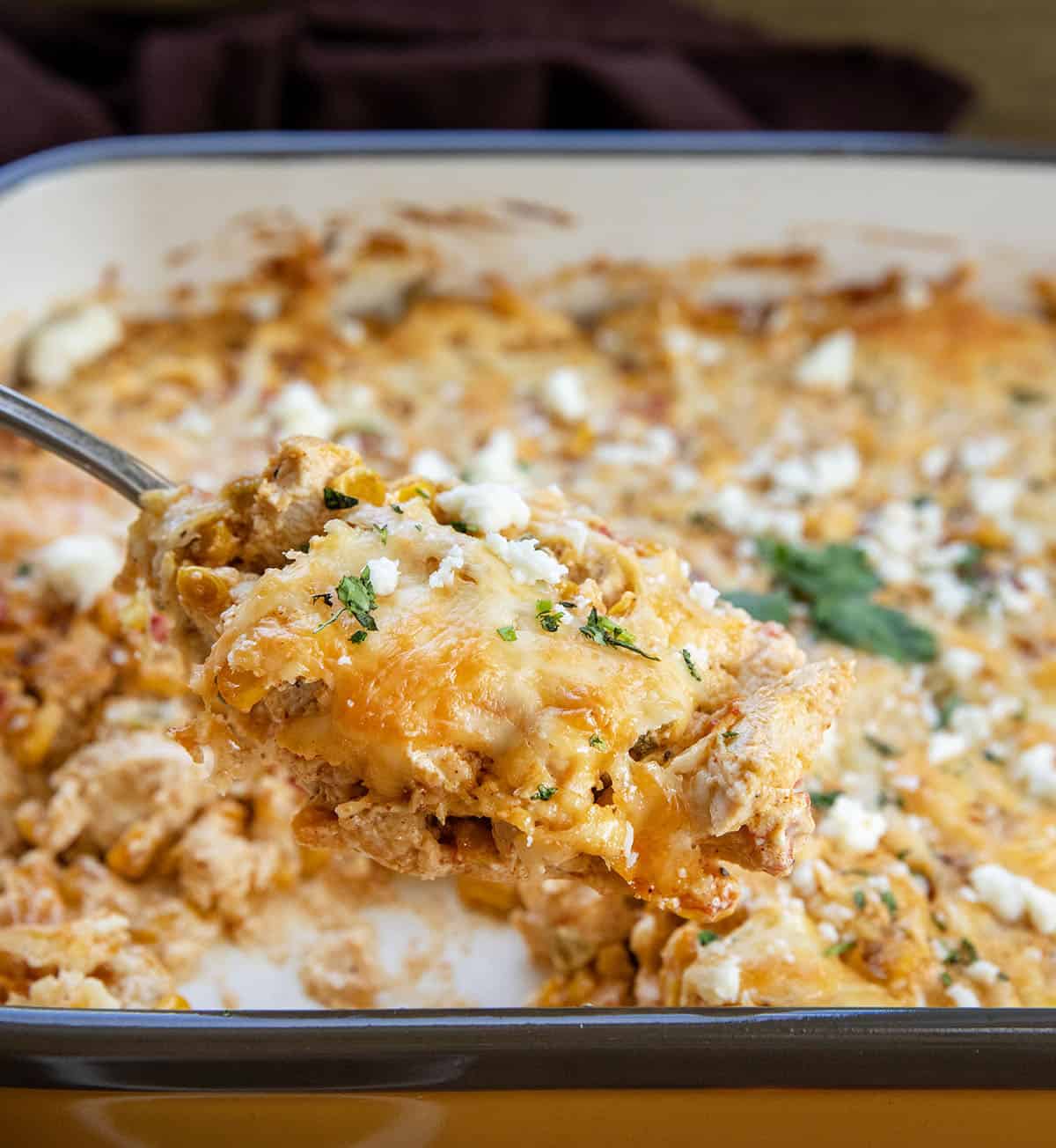 Spoonful of Street Corn Chicken Casserole being held above the casserole pan Spoonful of Street Corn Chicken Casserole being held above the casserole pan.