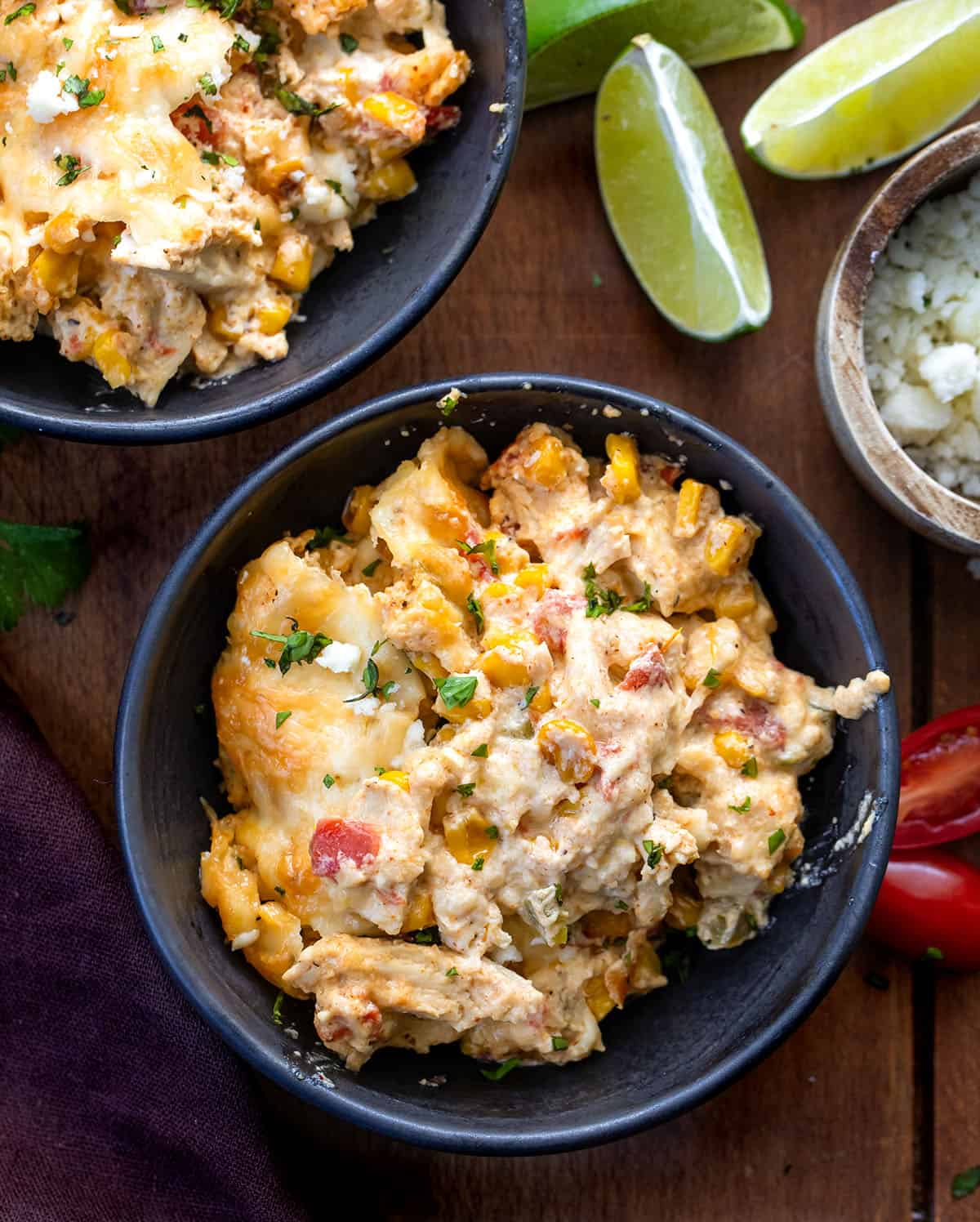Black bowls of Street Corn Chicken Casserole on a wooden table from overhead Black bowls of Street Corn Chicken Casserole on a wooden table from overhead.