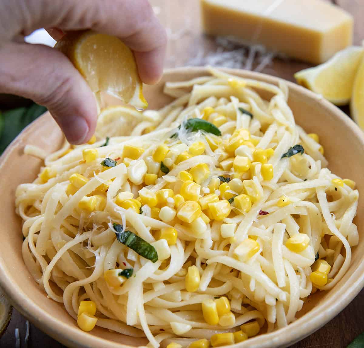 Squeezing a lemon wedge over Summer Lemon Corn Pasta Squeezing a lemon wedge over Summer Lemon Corn Pasta.