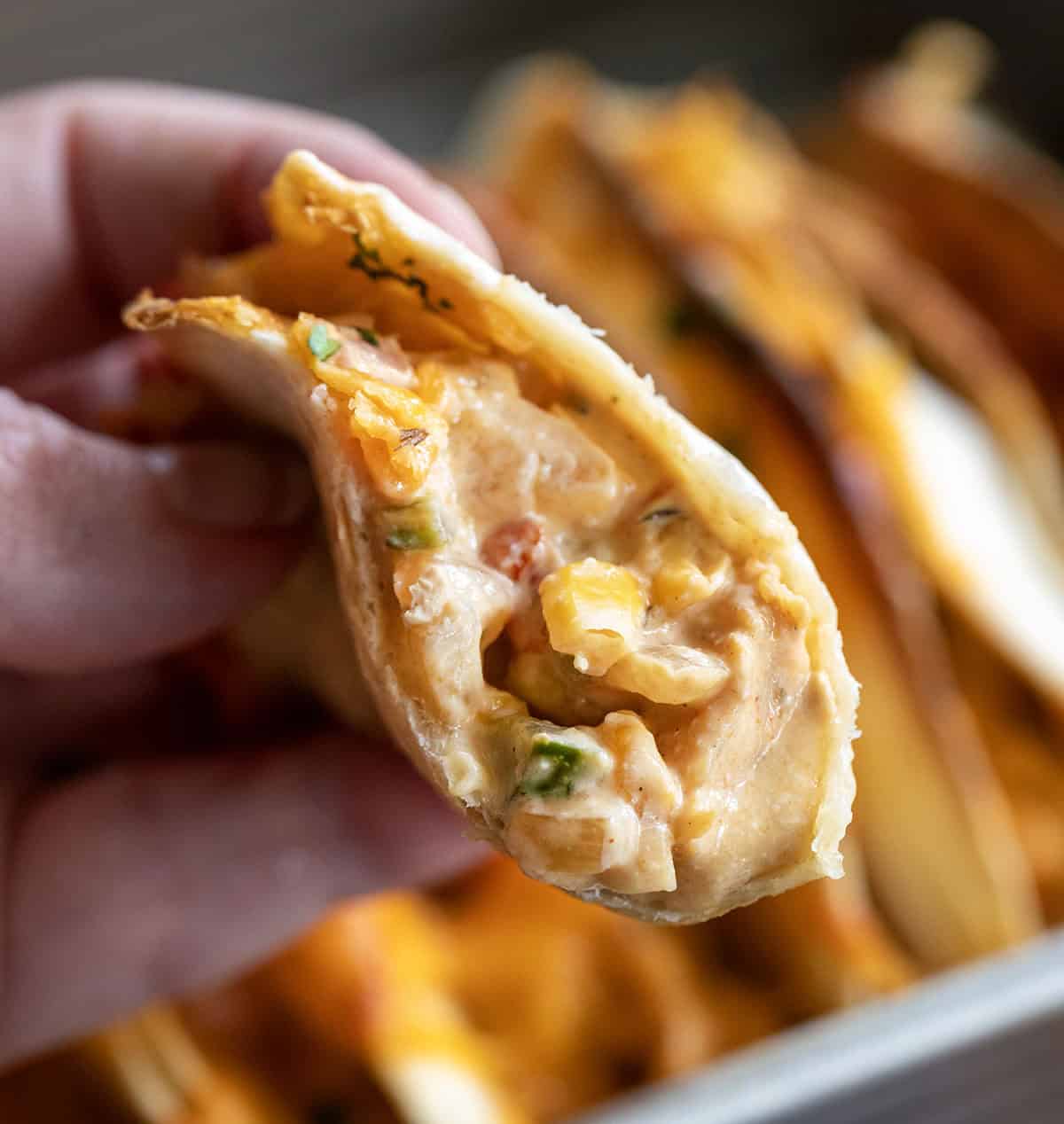 Hand holding a half eaten Baked Chicken Taco.