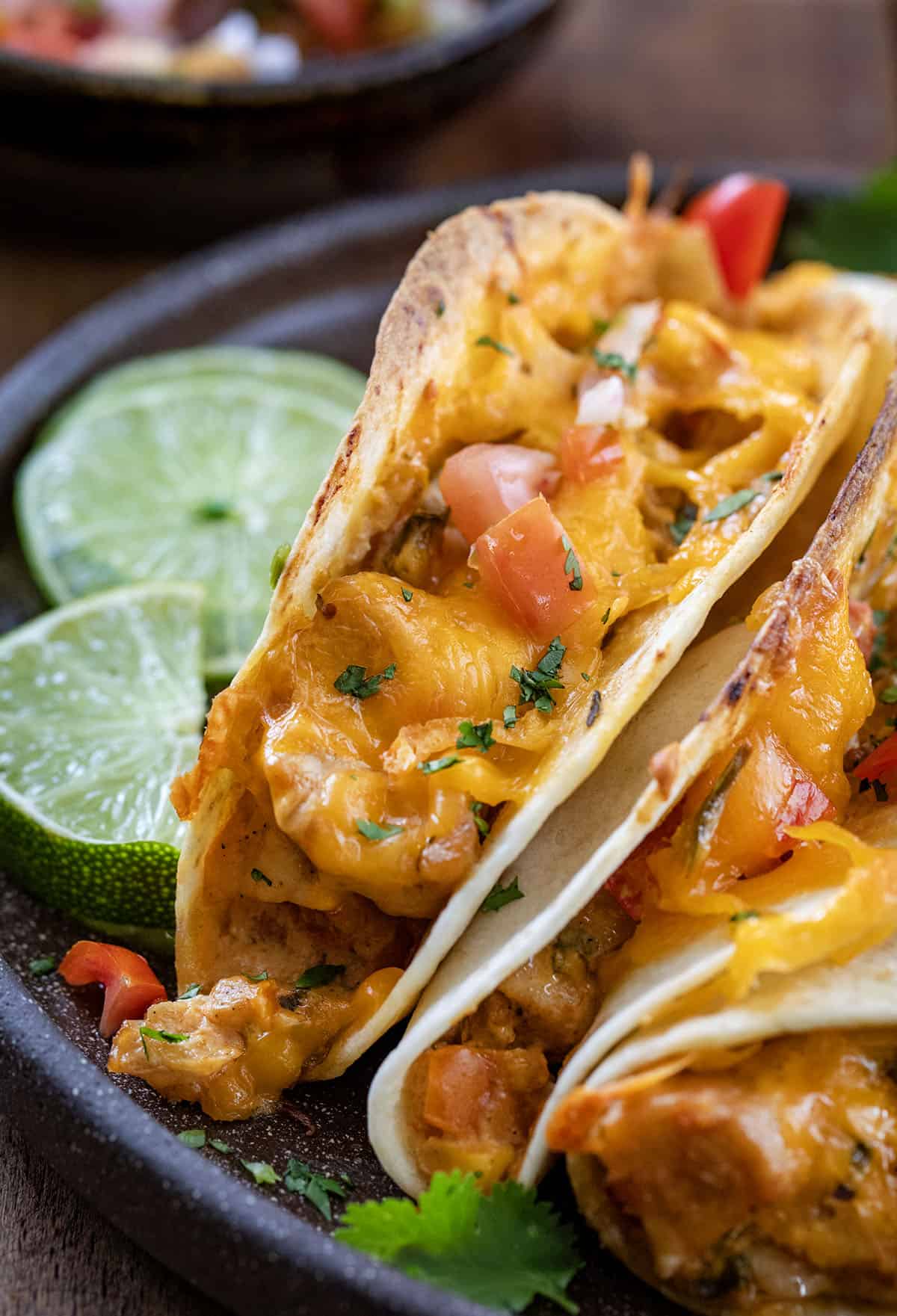 Close up of Baked Chicken Tacos on a plate with fresh cut lime.
