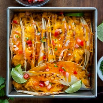 Baked Chicken Tacos in a pan on a wooden table from overhead.