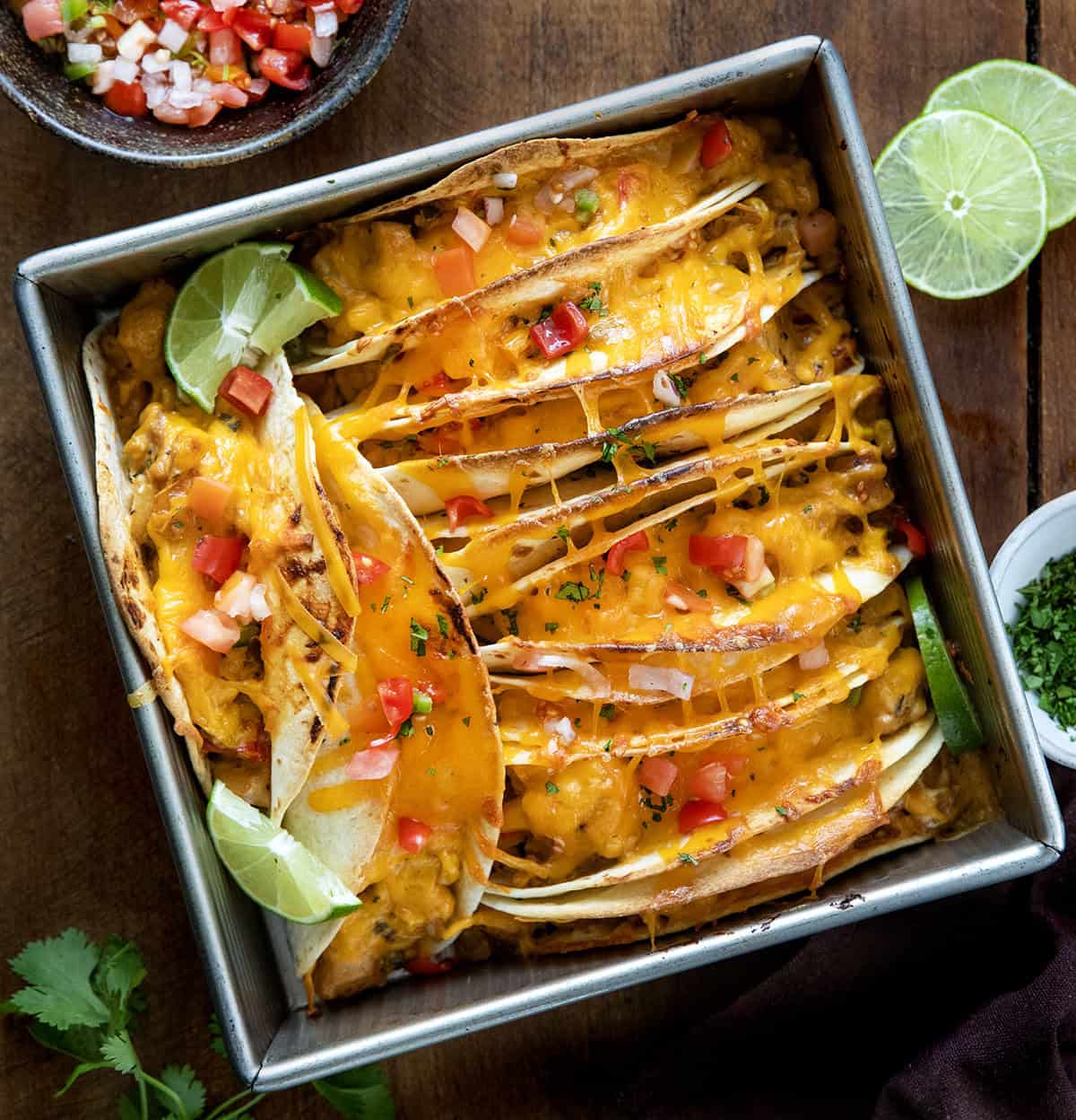 Baked Chicken Tacos in a pan on a wooden table from overhead.