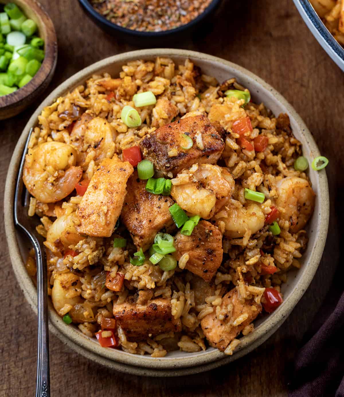 Plate of Cajun Salmon and Shrimp Fried Rice on a wooden table Plate of Cajun Salmon and Shrimp Fried Rice on a wooden table.