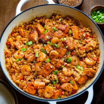 Skillet of Cajun Salmon and Shrimp Fried Rice on a wooden table.