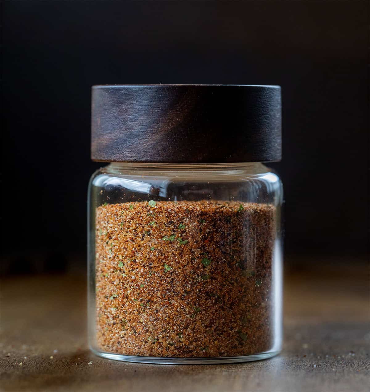 Jar of Elote Seasoning Mix on a wooden table with a wooden lid on the jar Jar of Elote Seasoning Mix on a wooden table with a wooden lid on the jar.