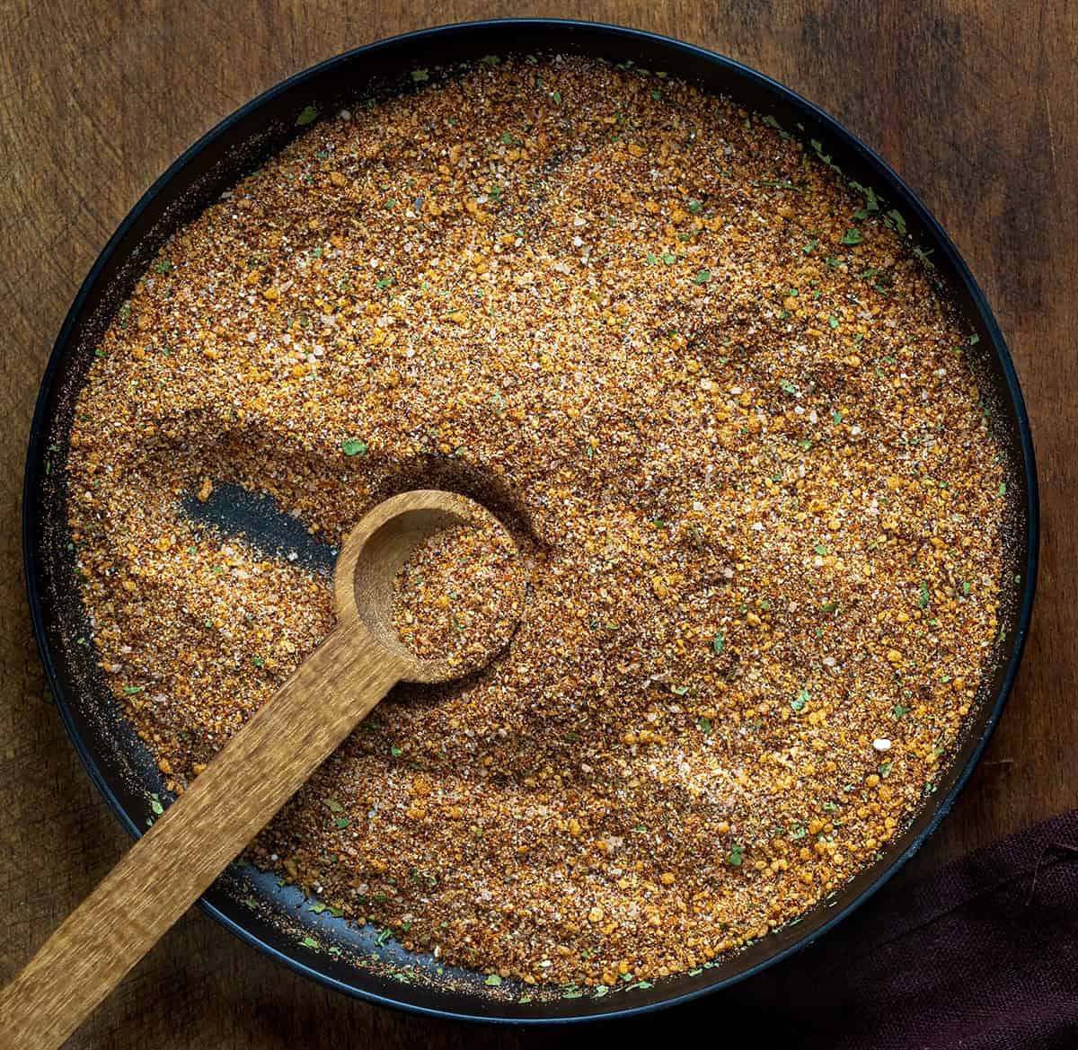 Black plate with Elote Seasoning Mix and a wooden spoon Black plate with Elote Seasoning Mix and a wooden spoon.