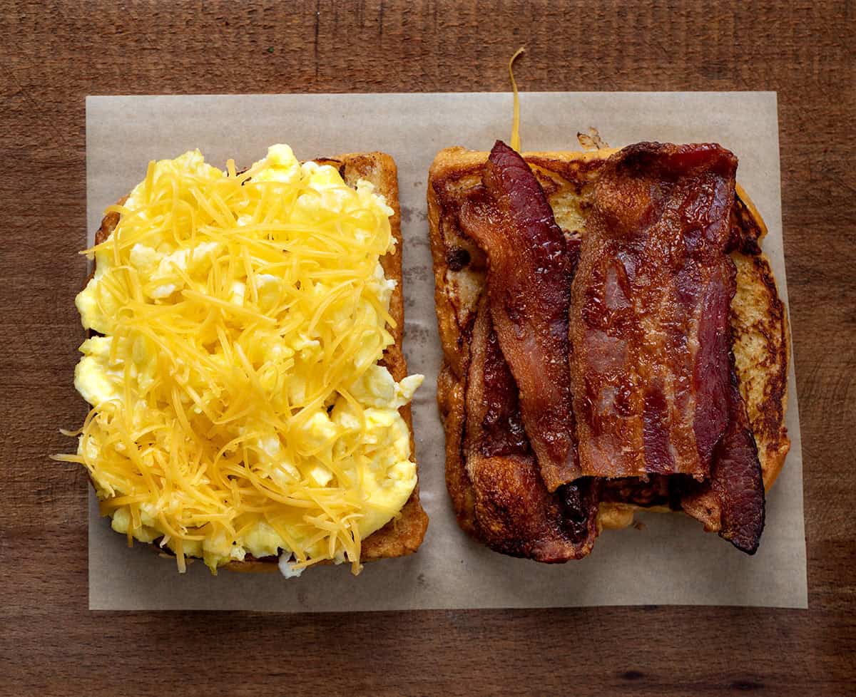 An open French Toast Breakfast Sandwich before assembling showing the eggs, cheese, and bacon An open French Toast Breakfast Sandwich before assembling showing the eggs, cheese, and bacon.