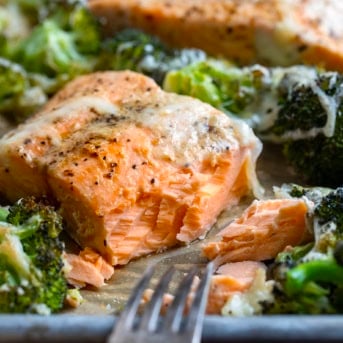 One piece of One Pan Baked Caesar Salmon with some of the salmon removed showing the flakey texture.