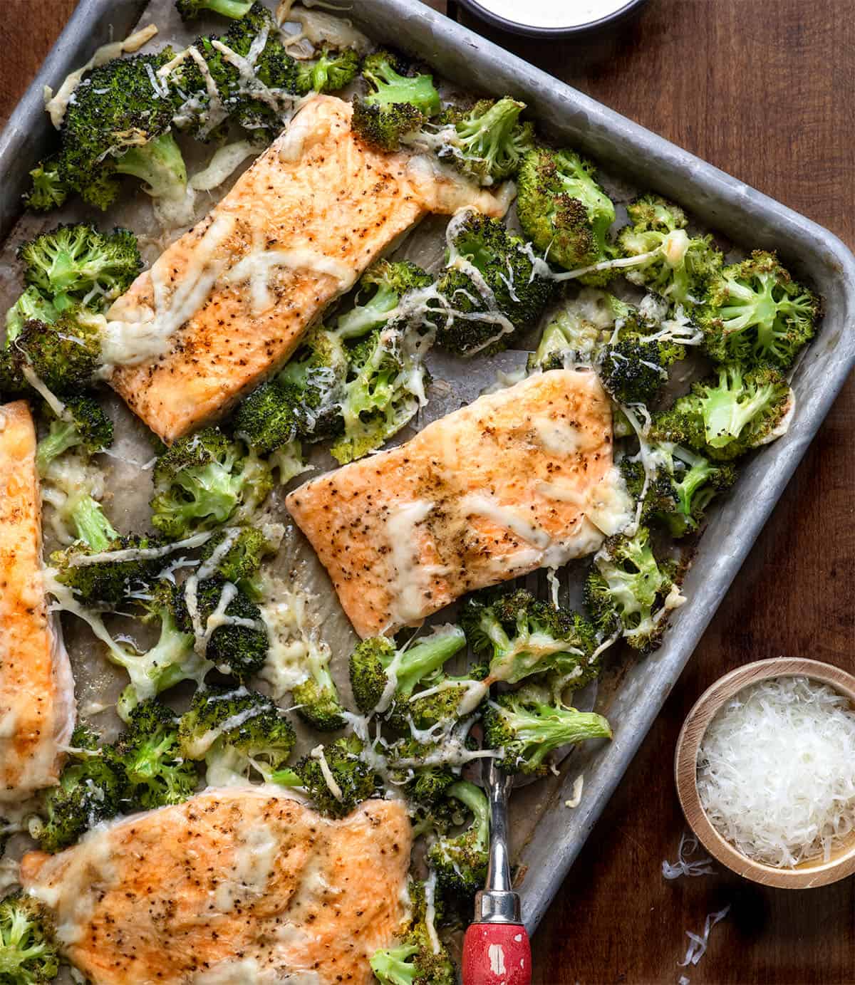 Close up of One Pan Baked Caesar Salmon with a spatula on a wooden table Close up of One Pan Baked Caesar Salmon with a spatula on a wooden table.
