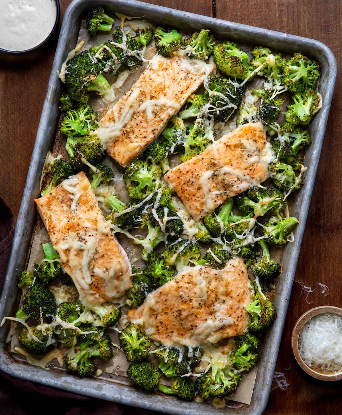 One Pan Baked Caesar Salmon on a wooden table from overhead One Pan Baked Caesar Salmon on a wooden table from overhead.