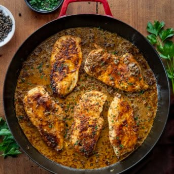 Skillet of Peppercorn Chicken on a wooden table from overhead.