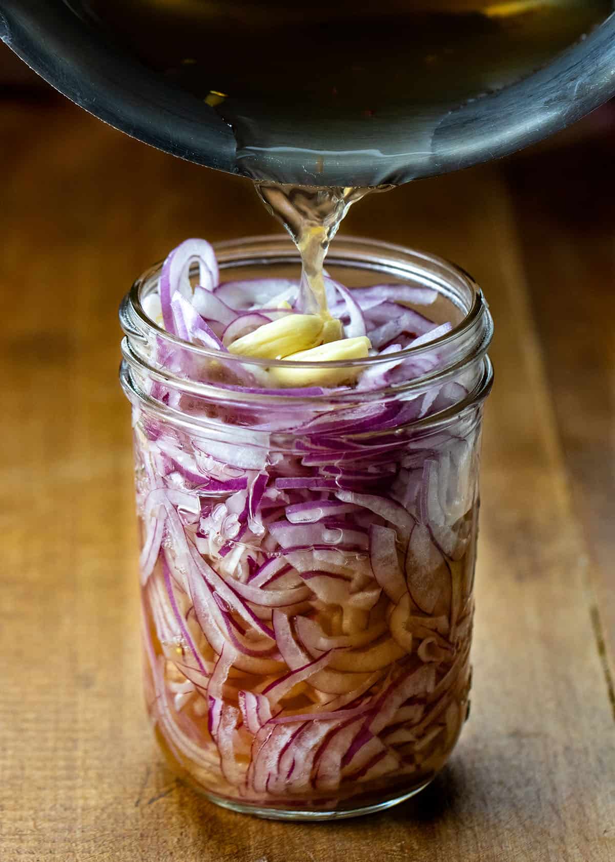 Pouring brining liquid over Pickled Red Onions Pouring brining liquid over Pickled Red Onions.