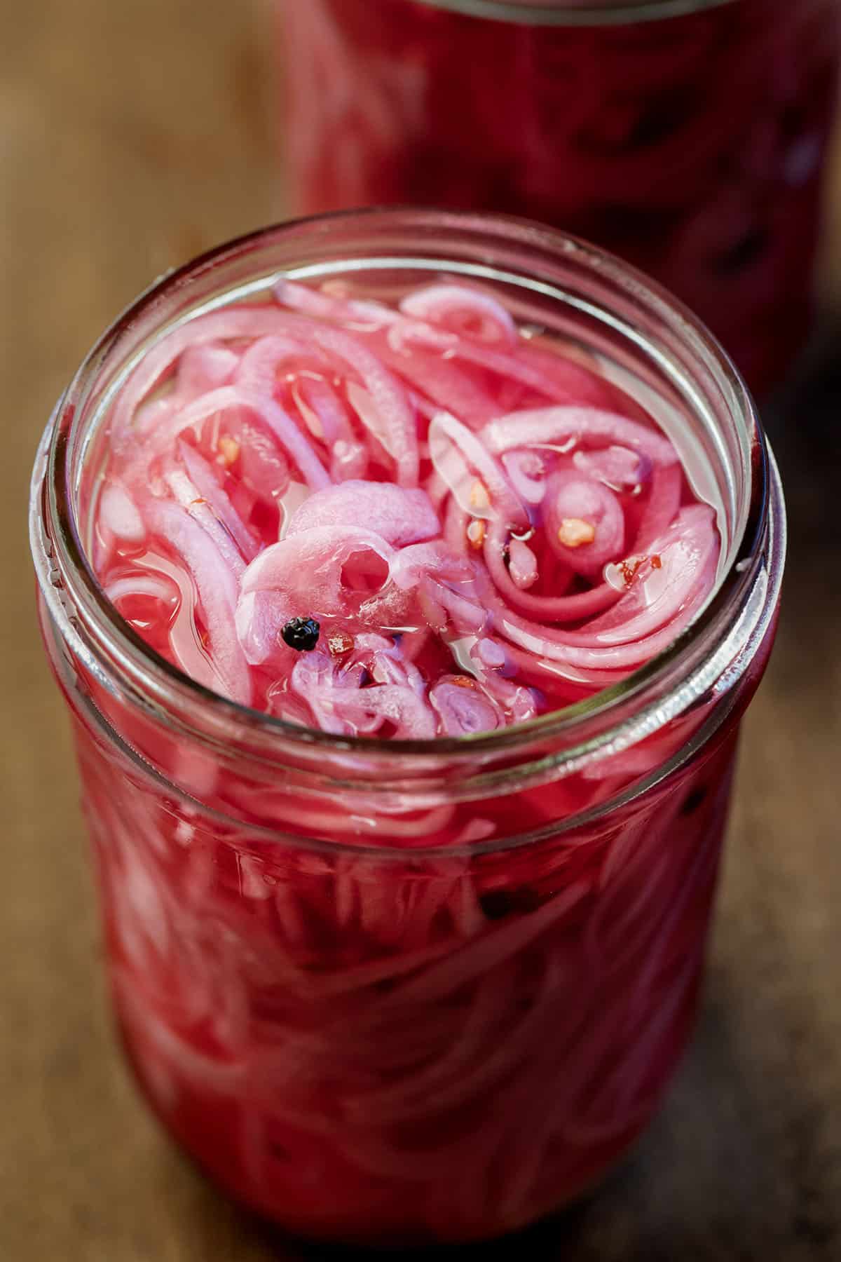 Close up looking into a jar of Pickled Red Onions Close up looking into a jar of Pickled Red Onions.