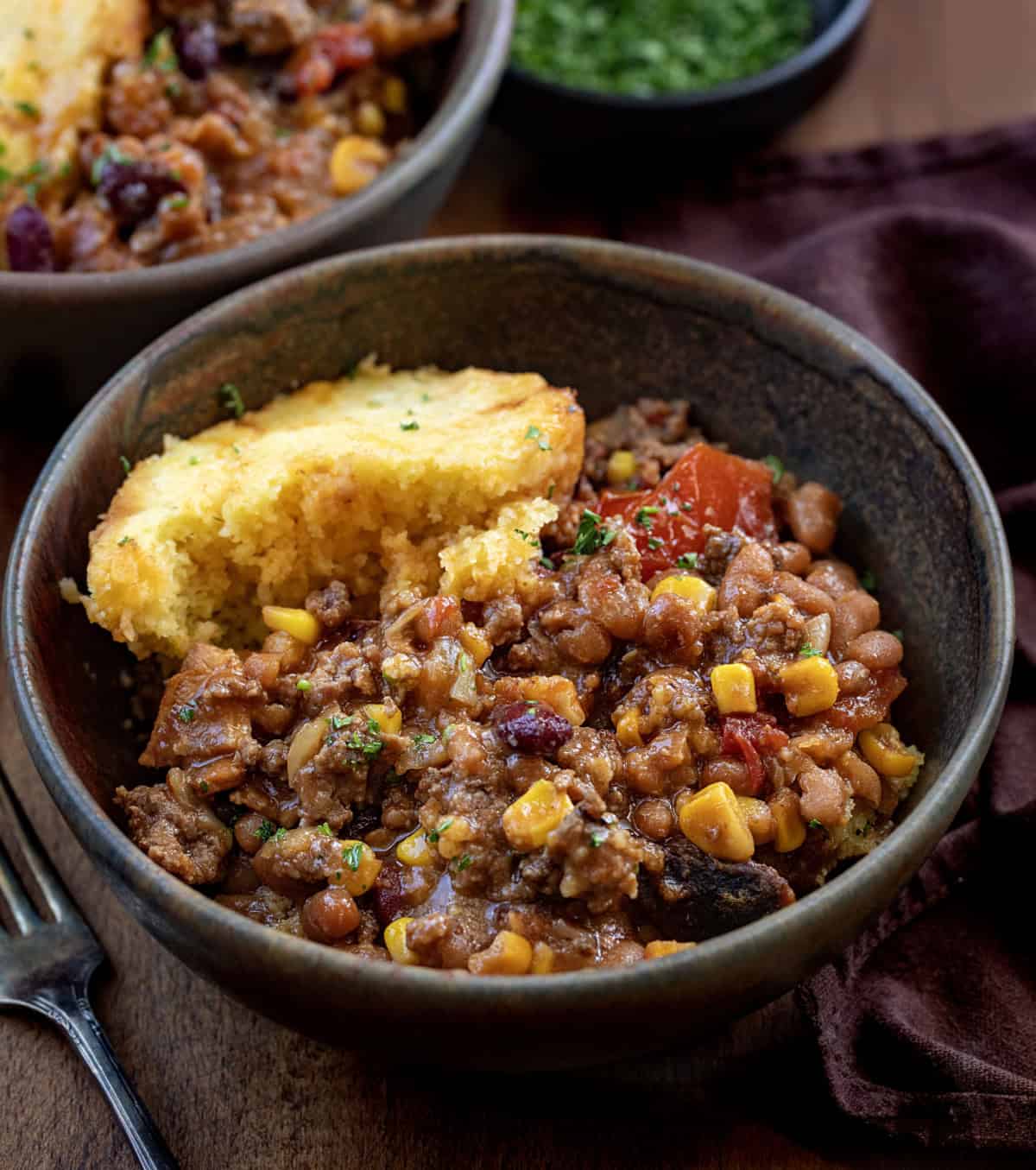 Bowls of Slow Cooker Cornbread Cowboy Casserole on a wooden table Bowls of Slow Cooker Cornbread Cowboy Casserole on a wooden table.