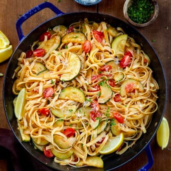 Skillet of Zucchini & Blistered Tomato Fettuccine on a wooden table from overhead.